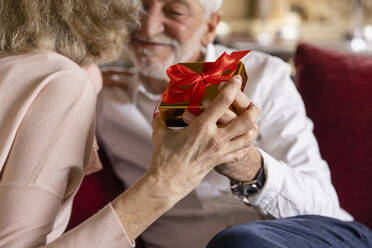 Älterer Mann und Frau mit Geschenk in einem Boutique-Hotel - EIF03702
