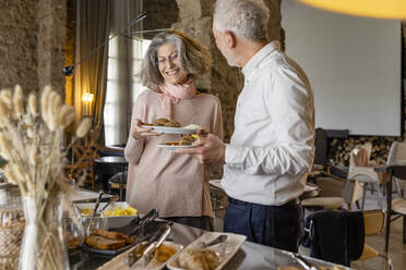 Glückliches älteres Paar beim Frühstücksbuffet in einem Boutique-Hotel - EIF03707