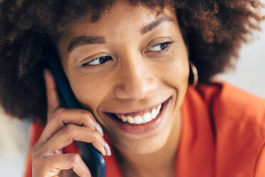 Lächelnde Geschäftsfrau, die mit einem Mobiltelefon spricht - GIOF15456