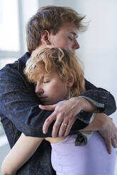 Young couple with eyes closed hugging each other - SUF00687