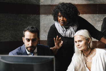 Zuversichtliche Finanzexperten, die während einer Sitzung im Büro über den Computer diskutieren - MASF29305