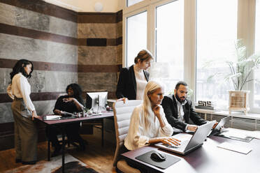 Multiracial colleagues working at desks in law office - MASF29336