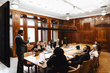 Ein Team von Anwälten bespricht sich mit einem Geschäftsmann im Sitzungssaal während einer Konferenz - MASF29368