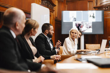 Weiblicher Finanzexperte diskutiert mit Kollegen in einer Sitzung im Sitzungssaal - MASF29420
