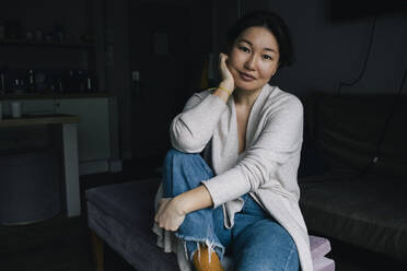 Portrait of smiling woman sitting in living room at home - MASF29463