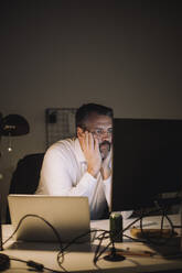 Ambitious businessman working on computer last minute at work place - MASF29543