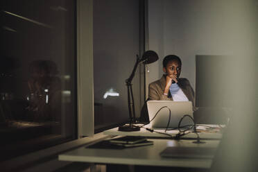 Geschäftsfrau bei der Arbeit am Computer in letzter Minute im Büro bei Nacht - MASF29574