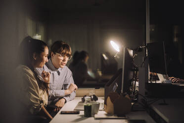 Multiracial weibliche Kollegen diskutieren über Laptop während der Arbeit spät am Arbeitsplatz - MASF29594