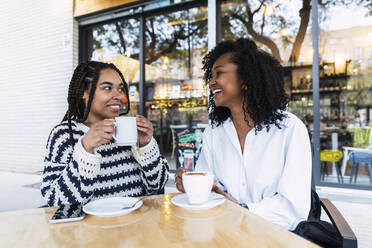 Glückliche Geschäftsfrauen mit Kaffeetassen in einem Straßencafé - PNAF03649