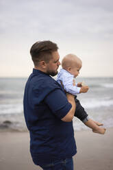 Vater mit Sohn am Strand stehend - SSGF00634