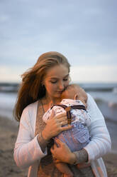 Junge blonde Frau mit Sohn am Strand bei Sonnenuntergang - SSGF00642