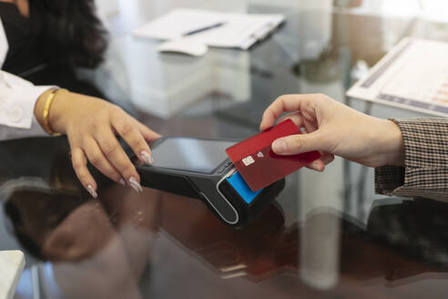 Frau beim kontaktlosen Bezahlen mit Kreditkarte - MTBF01203