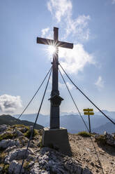 Gipfelkreuz unter bewölktem Himmel an einem sonnigen Tag - FOF13113