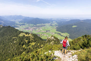 Frau mit Rucksack, stehend mit Wanderstock in den Bergen - FOF13116