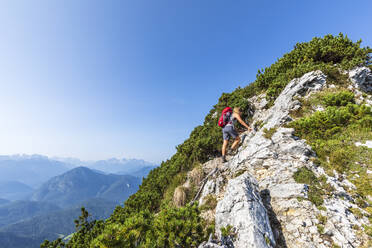 Wanderer mit Rucksack beim Bergsteigen an einem sonnigen Tag - FOF13121