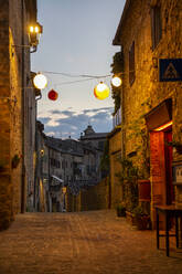 Italien, Provinz Siena, Radicondoli, Laternen beleuchten Altstadtgassen - MAMF02125