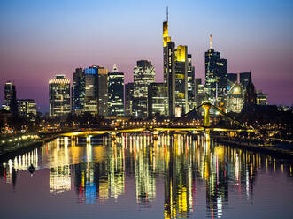 Germany, Hesse, Frankfurt, River Main canal at dusk with bridge and downtown skyscrapers in background - AMF09484