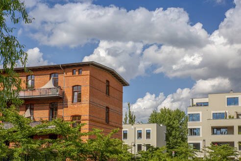 Deutschland, Berlin, Wolken über modernen Wohnhäusern im Neubaugebiet - MAMF02166