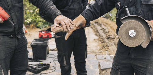 Bauarbeiter stapeln Hände auf der Baustelle - JCCMF06043