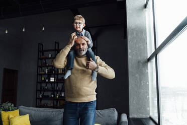 Älterer Mann trägt süßen Enkel auf den Schultern zu Hause - VPIF05664
