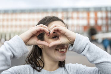 Happy young woman gesturing heart sign - WPEF05949