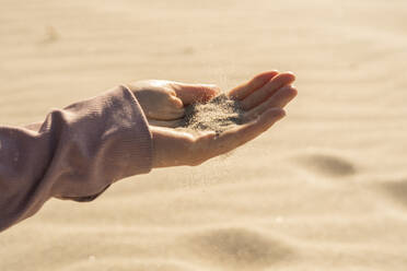 Frau mit Sand in der Hand an einem sonnigen Tag - SSGF00691