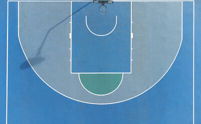 Draufsicht auf Basketballkorb auf Sportplatz mit blauer Oberfläche und Linien auf sonnigen Sommertag in der Stadt platziert - ADSF34516