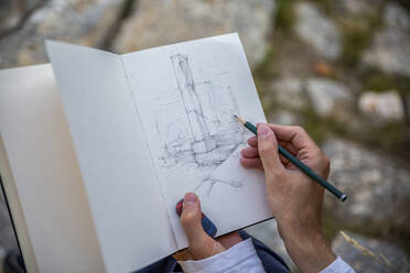 Tourist drawing ruined column in scribble book - MAMF02182