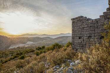 Alte Ruinen an einer archäologischen Stätte mit Bergen im Hintergrund, Orraon, Arta, Griechenland - MAMF02184