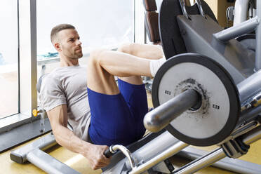 Mann beim Training an der Beinpresse im Fitnessstudio - IFRF01568