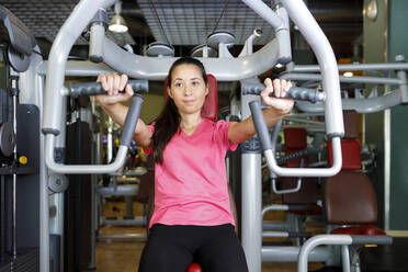 Frau beim Training mit Fitnessgerät im Fitnessstudio - IFRF01570