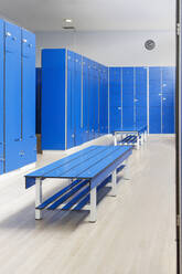 Blue bench in empty locker room at gym - IFRF01604
