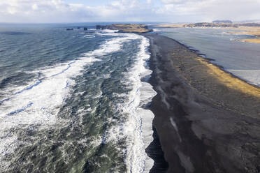 Luftaufnahme der rollenden Wellen am Reynisfjara, einem schwarzen Sandstrand an der wilden Küste in Island. - AAEF14401