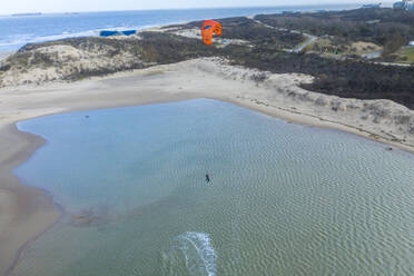 Luftaufnahme einer Person beim Windsurfen zwischen Sanddünen in einer Bucht in Retranchement, Niederlande. - AAEF14435