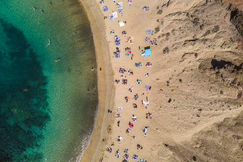 Luftaufnahme von Menschen am Strand von Playa del Papagayo (Papagayo Beach) bei Playa Blanca, Lanzarote, Kanarische Inseln, Spanien. - AAEF14482