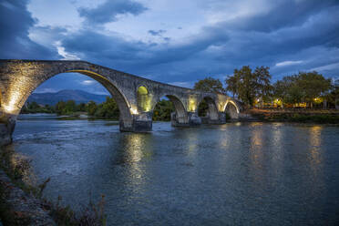 Beleuchtete Brücke von Arta am Fluss Arachthos bei Nacht in Griechenland - MAMF02196