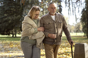 Senior couple walking at public park - ABIF01635