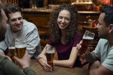 Group of friends having beer and socializing in a pub - ABIF01675