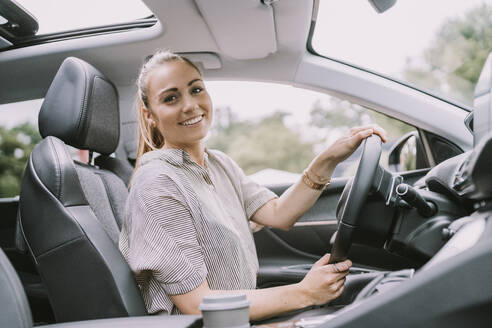 Glückliche junge Frau, die auf einer Autoreise Auto fährt - MFF09004