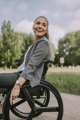 Happy disabled young woman in park - MFF09080