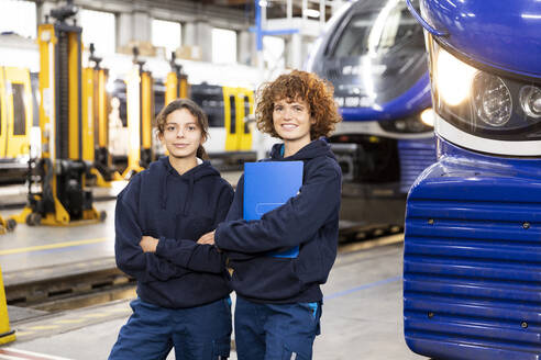 Selbstbewusste Ingenieure stehen an der Einschienenbahn in der Fabrik - FKF04781