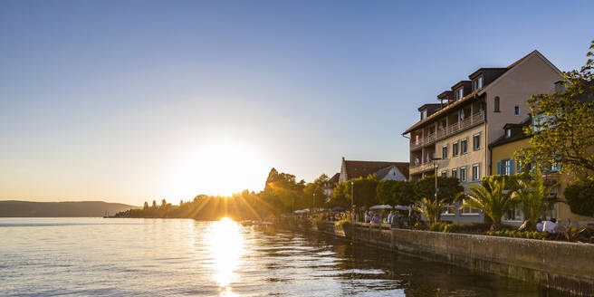 Deutschland, Baden-Württemberg, Uberlingen, Promenade am Bodenseeufer bei Sonnenuntergang - WDF06898