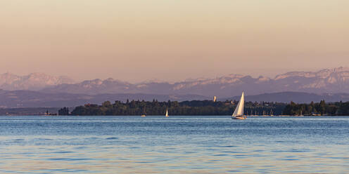 Germany, Baden-Wurttemberg, Uberlingen, Sailboats in Lake Constance at dusk with Bodanruck peninsula in background - WDF06899