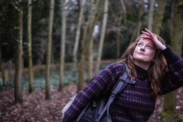 Junge Frau mit Rucksack beim Wandern im Wald - AMWF00218