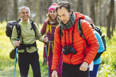 Mann mit Fernglas beim Trekking mit Freunden im Wald - JCCMF06070