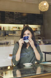Frau trinkt Kaffee im Cafe - ISF25614