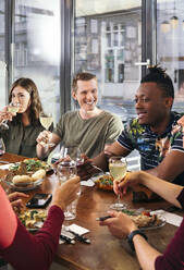 Eine Gruppe von Freunden genießt eine Mahlzeit im Restaurant - ISF25652