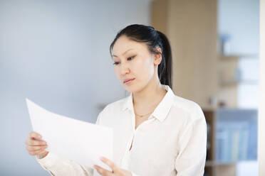 Serious businesswoman looking at documents in office - ISF25685