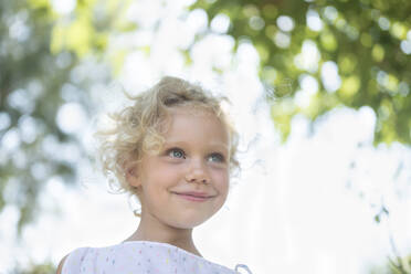 Smiling girl with blond hair at garden - SVKF00120