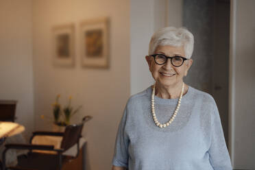 Happy senior woman with white hair standing at home - JOSEF08528